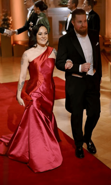 Mira Luoti punaisessa iltapuvussa ja Olli Saksa frakissa Linnan juhlissa 2024.