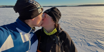 Antti Häkkänen ja Henna Pajulammi suutelevat aurinkoisella hiihtoretkellä Mäntyharjulla.