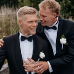 Aki Samuli eli Aki Kirvesniemi ja puoliso Niko poseeraavat mustissa smokeissa hääpäivänään elokuussa 2026.