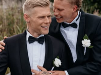 Aki Samuli eli Aki Kirvesniemi ja puoliso Niko poseeraavat mustissa smokeissa hääpäivänään elokuussa 2026.