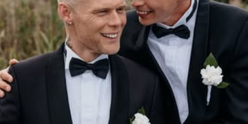 Aki Samuli eli Aki Kirvesniemi ja puoliso Niko poseeraavat mustissa smokeissa hääpäivänään elokuussa 2026.